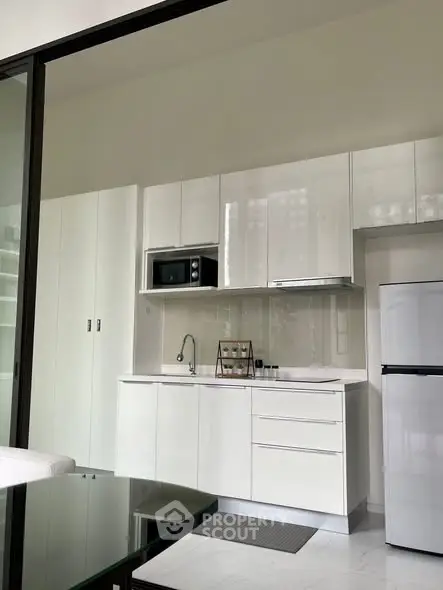 Modern minimalist kitchen with sleek white cabinets and built-in appliances