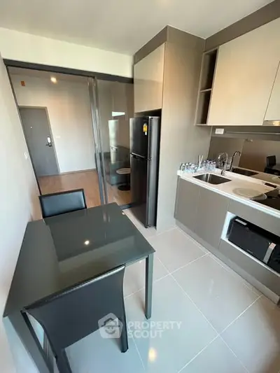 Modern kitchen with sleek cabinetry and dining area in a stylish apartment.