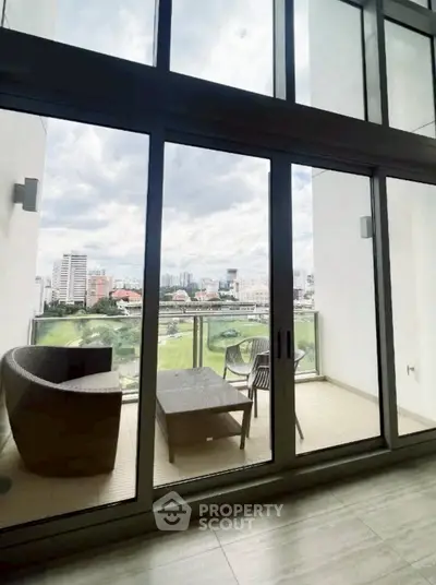 Spacious balcony with stunning city view and modern outdoor furniture.