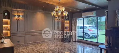 Luxurious living room with elegant wood paneling and large window overlooking garden and parked car.