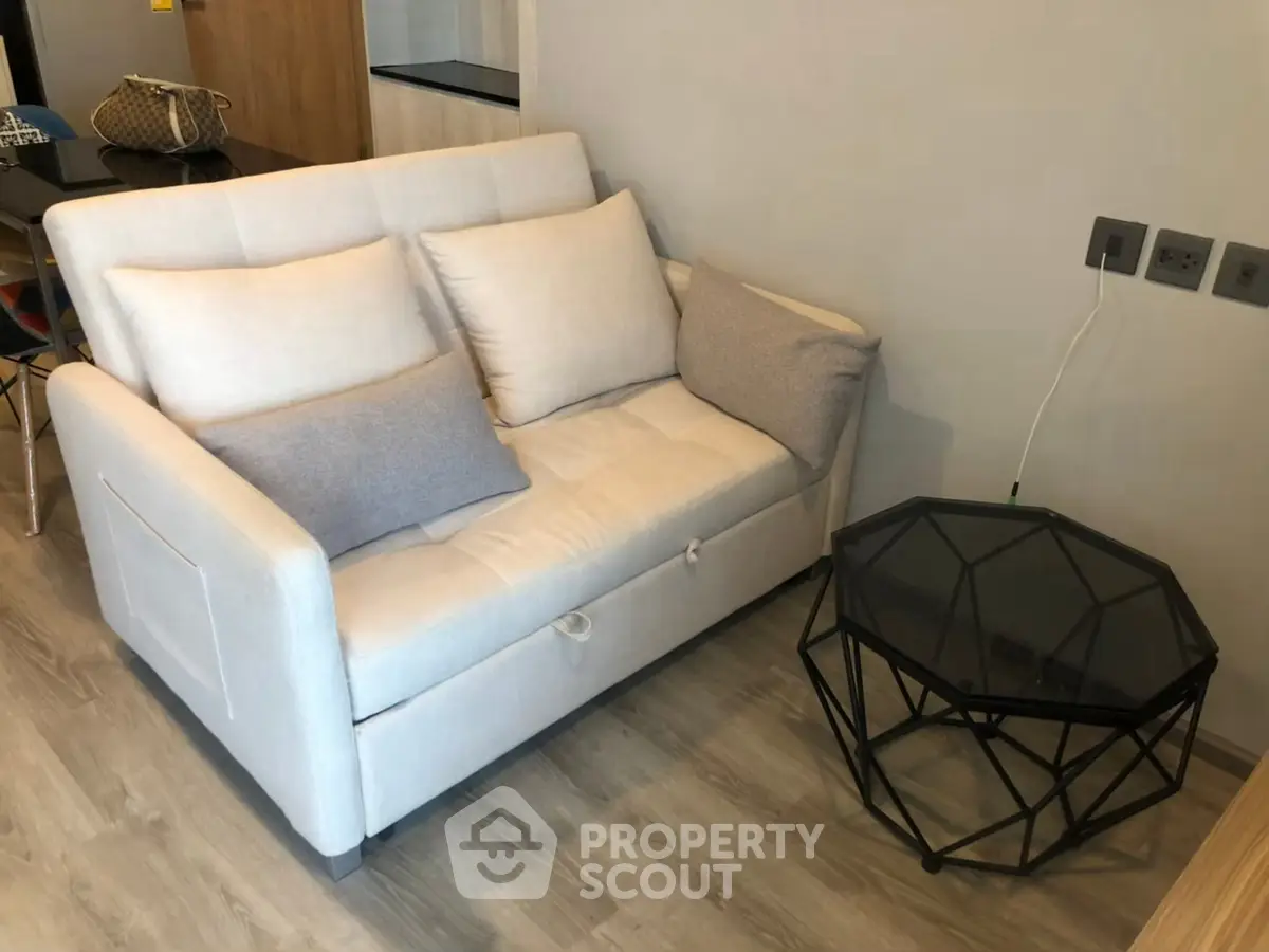 Cozy living room with modern sofa and geometric coffee table in stylish apartment.
