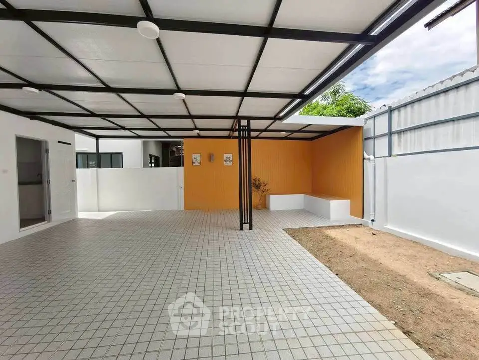 Spacious modern covered parking area with tiled flooring and vibrant accent wall.