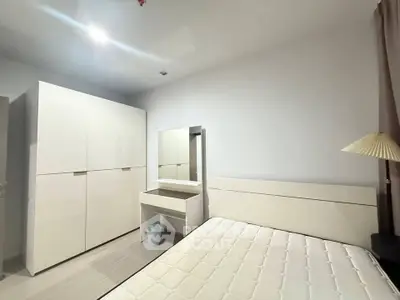 Modern bedroom with sleek white furniture and ample storage space