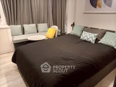 Cozy bedroom with modern decor and comfortable seating area, perfect for relaxation.