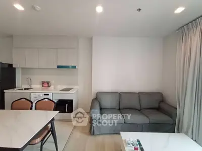 Modern living room with open kitchen layout and cozy gray sofa