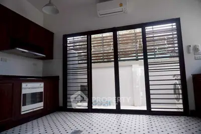 Modern kitchen with open layout and large sliding glass doors leading to outdoor space.
