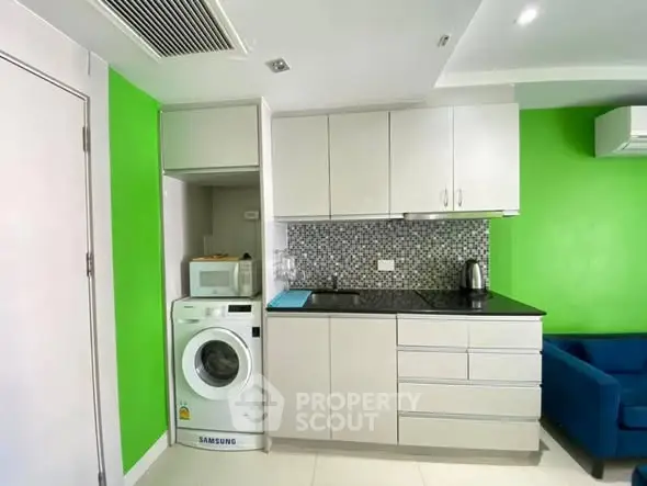 Modern kitchen with vibrant green walls and built-in washing machine