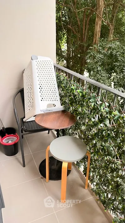 Charming balcony with lush greenery and cozy seating area, perfect for relaxation.