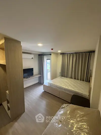 Modern bedroom with balcony access and sleek furnishings in a stylish apartment.