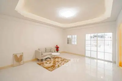 Spacious living room with modern decor and large windows leading to a balcony, perfect for relaxation.