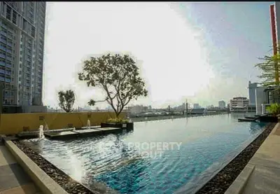 Luxurious rooftop pool with stunning city views in modern high-rise building.