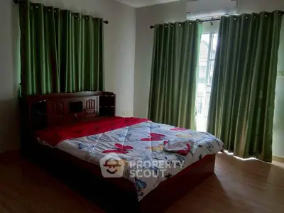 Spacious bedroom with natural light and elegant green curtains