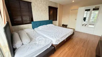 Spacious bedroom with twin beds and modern wardrobe in elegant home.