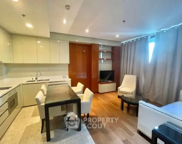 Modern open-layout living room with kitchen, dining area, and cozy seating.