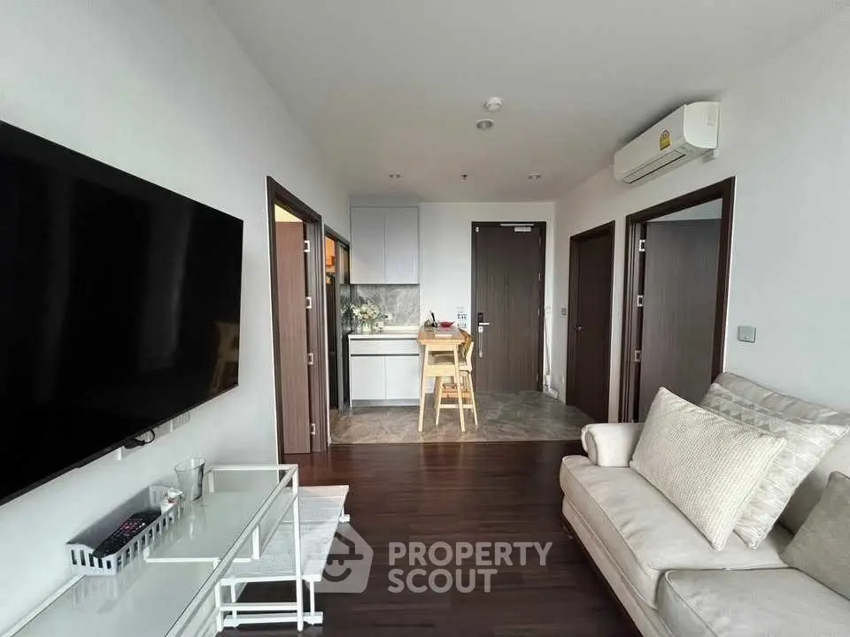 Modern living room with sleek TV and cozy seating in stylish apartment