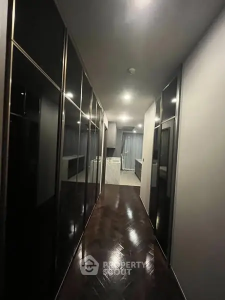 Sleek modern hallway with glossy black cabinets and elegant lighting