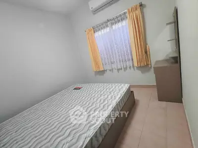 Cozy bedroom with air conditioning and natural light, featuring a comfortable bed and neutral decor.