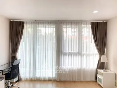 Bright and airy living room with floor-to-ceiling windows and elegant curtains, perfect for natural light lovers.