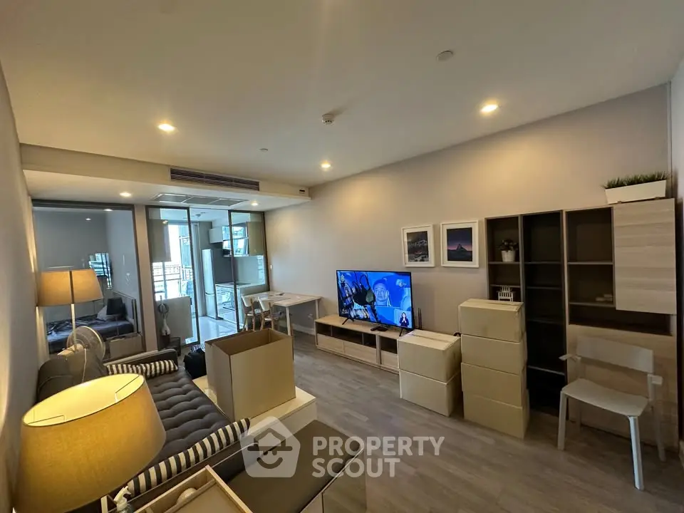 Modern living room with stylish furniture and TV, featuring a cozy ambiance and contemporary design.