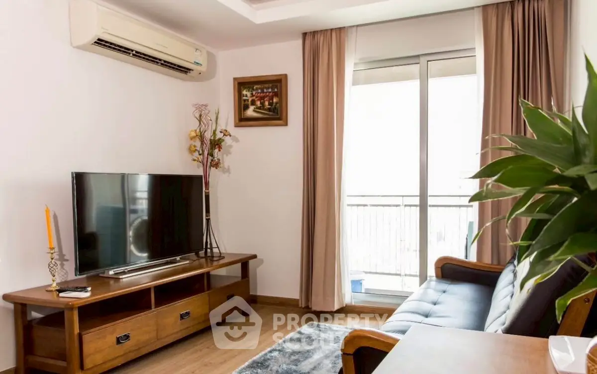 Charming living room with modern decor and large TV, perfect for relaxation.