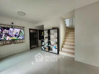 Spacious modern living room with sleek staircase and built-in shelving, perfect for stylish urban living.
