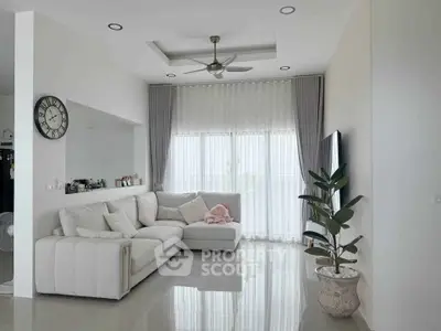 Modern living room with sleek design, featuring a cozy sectional sofa, elegant curtains, and a ceiling fan.