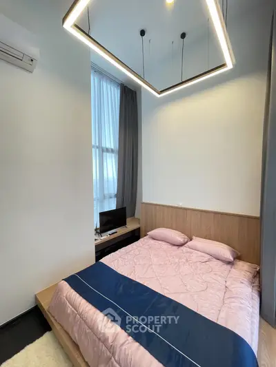 Modern bedroom with stylish lighting and cozy bedding in a contemporary apartment.