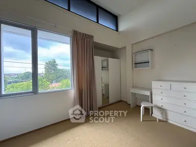 Spacious bedroom with large window and ample storage in a modern home