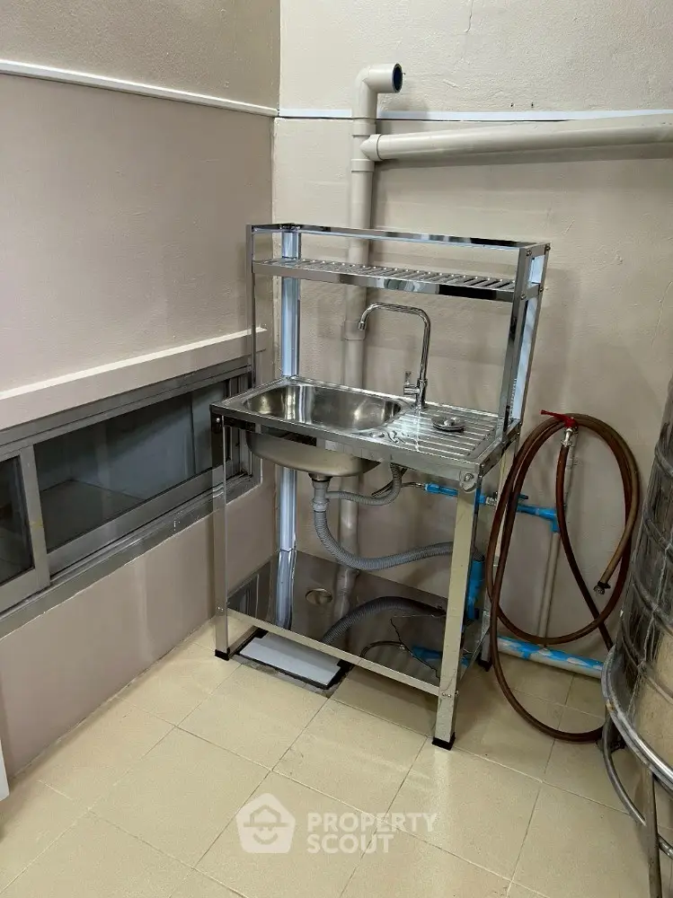 Compact utility sink in a functional corner setup with plumbing fixtures