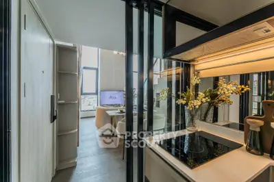 Modern open-layout kitchen with sleek design and cozy living area, featuring large windows and stylish decor.