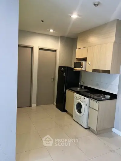Modern kitchen with integrated appliances and sleek cabinetry in a compact layout.