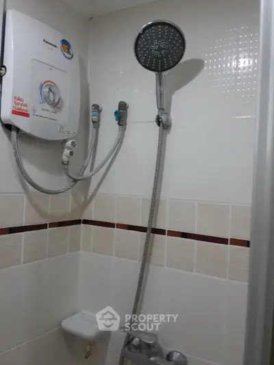 Compact bathroom shower area with water heater and modern fixtures