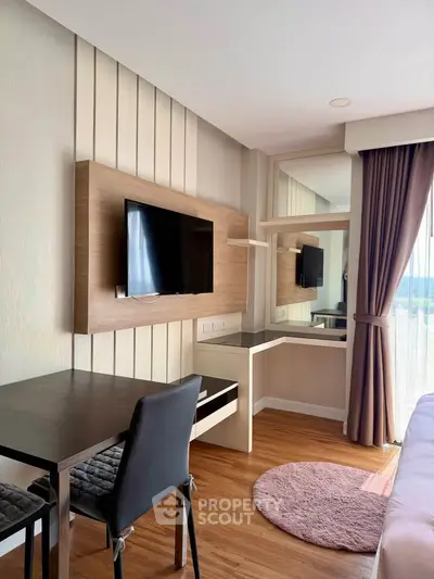 Modern bedroom with wall-mounted TV and stylish desk in a bright apartment
