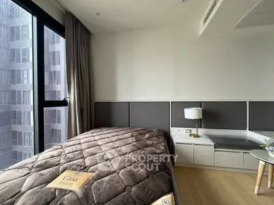 Modern bedroom with cozy bed and large window in a high-rise apartment.