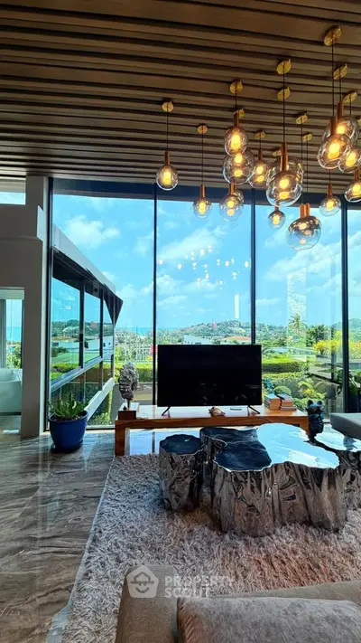 Luxurious living room with stunning floor-to-ceiling windows and modern decor, offering breathtaking views.