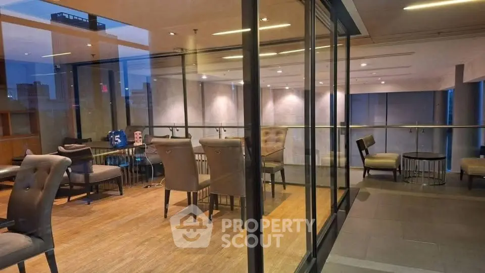Modern co-working space with glass walls and stylish furniture in a contemporary building.