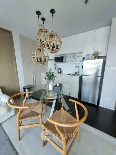 Modern kitchen with stylish lighting and dining area in contemporary apartment.