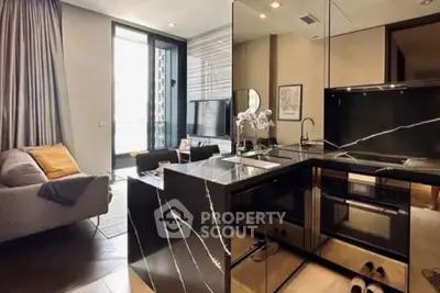 Modern open-layout kitchen with sleek black countertops and cozy living area in a stylish apartment.