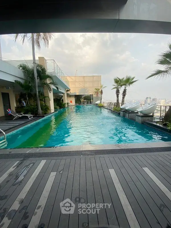 Stunning rooftop pool with city views and lush palm trees, perfect for relaxation and leisure.