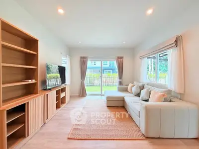 Spacious living room with modern decor and garden view, perfect for relaxation and entertainment.