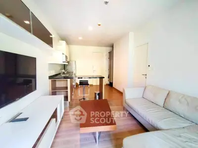 Modern living room with open kitchen layout and sleek furnishings