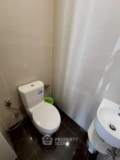 Modern bathroom with sleek design and compact layout, featuring a toilet and sink.