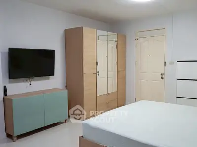 Modern bedroom with minimalist furniture and wall-mounted TV