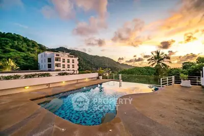Stunning rooftop pool with breathtaking sunset views and lush greenery, perfect for luxury living.