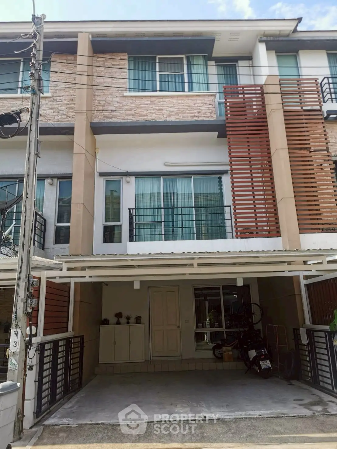 Modern townhouse exterior with balcony and parking space in urban setting