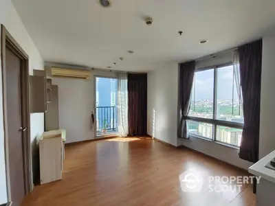 Spacious corner unit with big windows and city view, featuring wooden flooring and modern design.