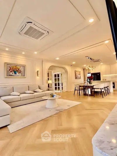Luxurious open-plan living room with elegant decor and spacious dining area, perfect for modern living.