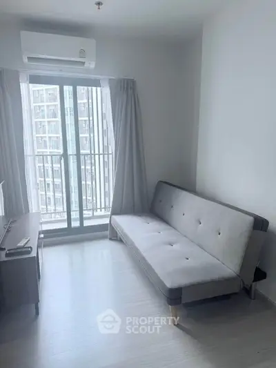 Modern living room with sleek sofa and large window offering city view