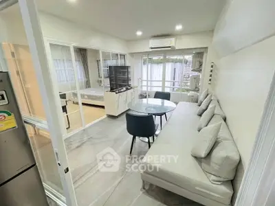 Modern open-plan living room with sleek furniture and large windows for natural light.