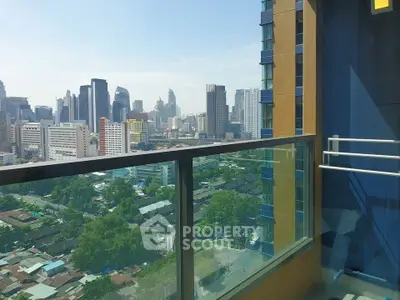 Stunning cityscape view from a high-rise balcony with glass railing.